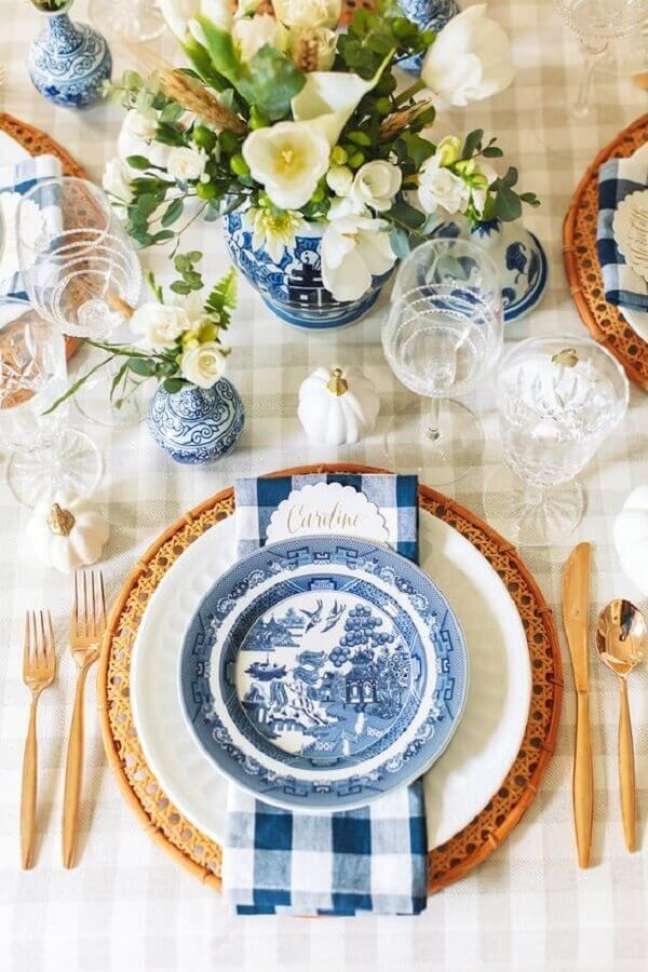 11. Arranjos de flores para decoração de mesa posta de ano novo bege e azul Foto Pizzazzerie