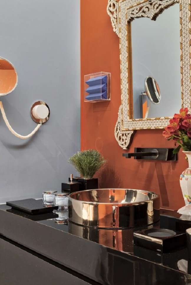 29. Banheiro moderno com torneira de parede preta e cuba redonda dourada – Projeto Michel Safatle