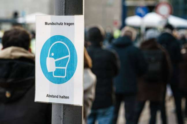 Um cartaz em Berlim, na Alemanha, recomendando o uso de máscara