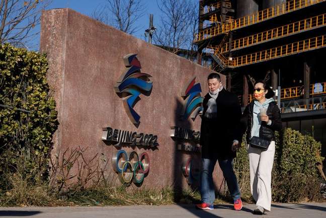 Duas pessoas caminham em frente à sede do comitê organizador dos Jogos Olímpicos e Paraolímpicos de Inverno de 2022 em Pequim, China, em 30 de novembro de 2021. REUTERS/Thomas Peter