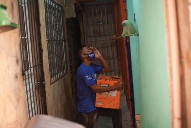 Membro do Favela Brasil Xpress com produtos a serem entregues em Paraisópolis, São Paulo