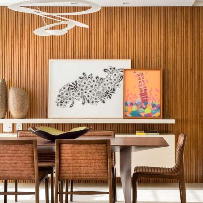 52. Ripado de madeira na parede de sala de jantar decorada com quadros apoiados em prateleira – Foto: Paula Neder Arquitetura