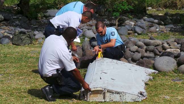 Em 2015, policiais franceses inspecionam um grande pedaço de destroços de avião encontrados na ilha francesa de La Reunion, no Oceano Índico