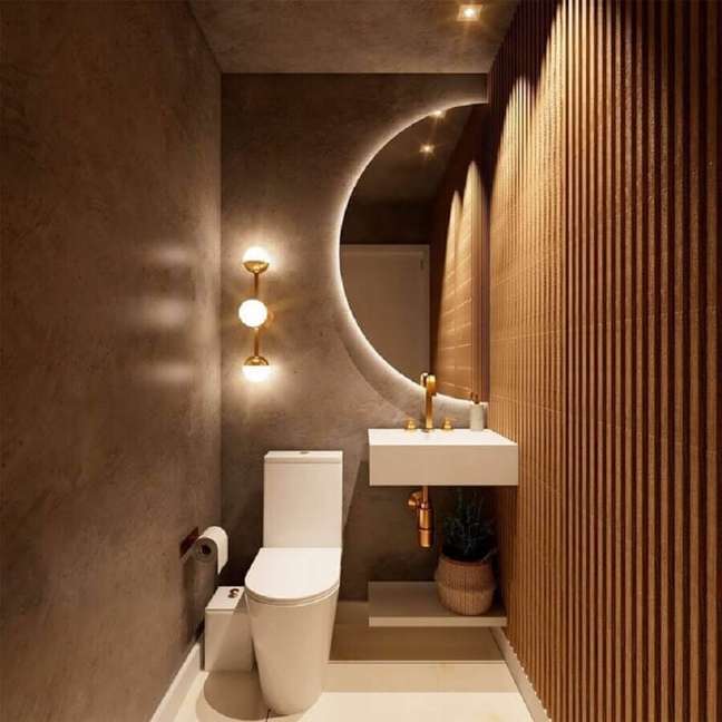 8. Cores neutras para lavabo pequeno e moderno decorado com espelho meia lua e parede ripada de madeira – Foto: Arquiteto Renan Adams