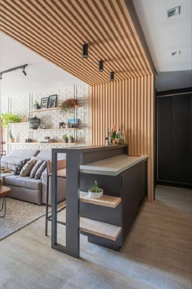 39. Parede ripada de madeira para decoração de cozinha americana integrada com sala de estar – Foto: RAL Arquitetura + Design