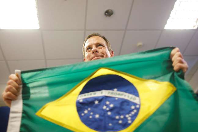 João Doria posa para foto com a bandeira do Brasil