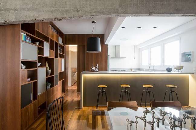 34. Banco para cozinha americana integrada com sala de jantar decorada com estante de madeira planejada – Foto: A.M Studio Arquitetura
