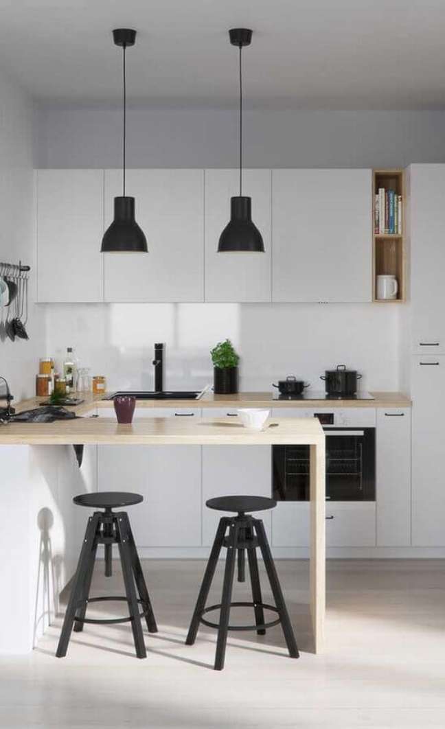 22. Banco para cozinha americana branca decorada com bancada de madeira e pendente preto – Foto: Apartment Therapy