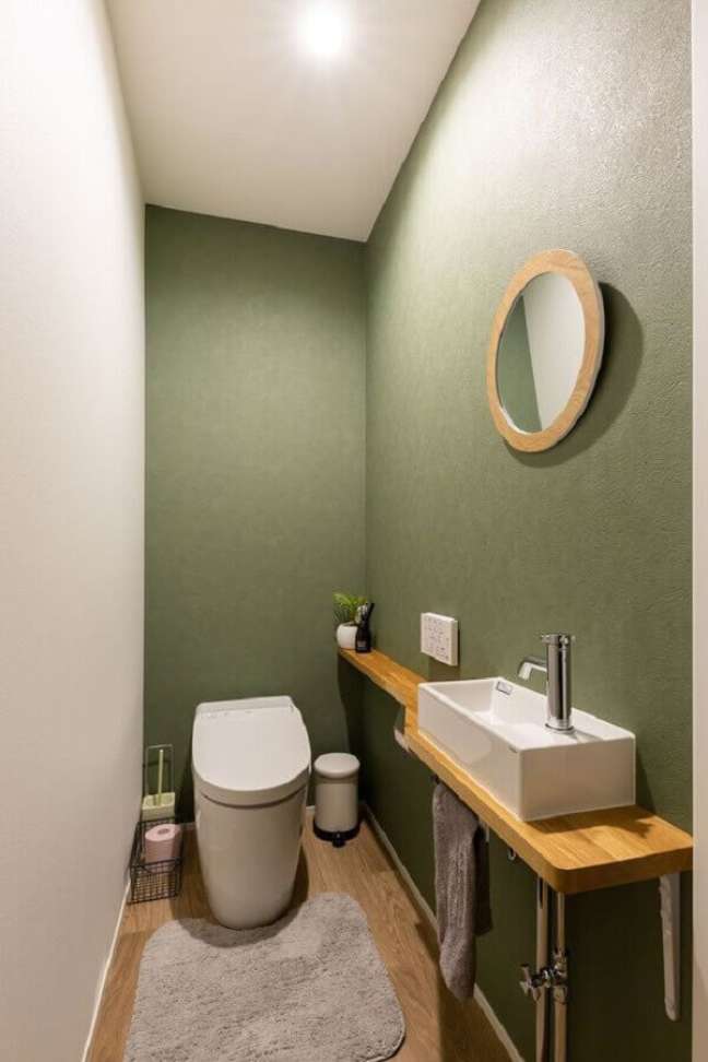 5. Decoração clean para banheiro verde musgo pequeno com bancada de madeira – Foto: ArchZine