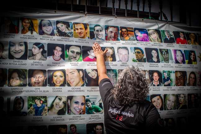 Familiar toca em cartaz com fotos das vítimas da boate Kiss em frente ao Foro Central de Porto Alegre