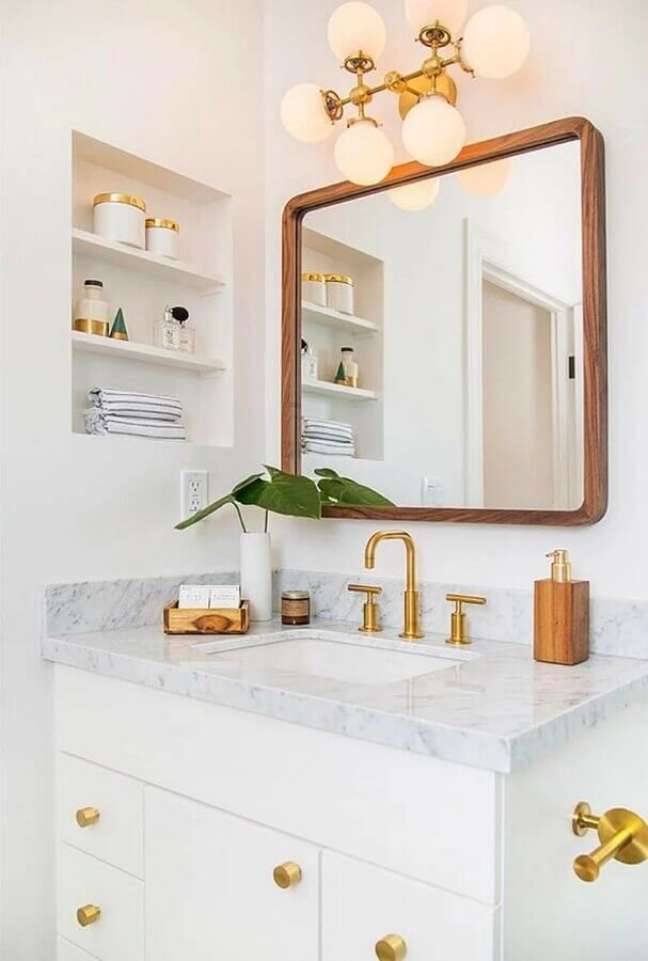 20. Decoração clean com detalhes em dourado para banheiro com nicho embutido – Foto: Archzine