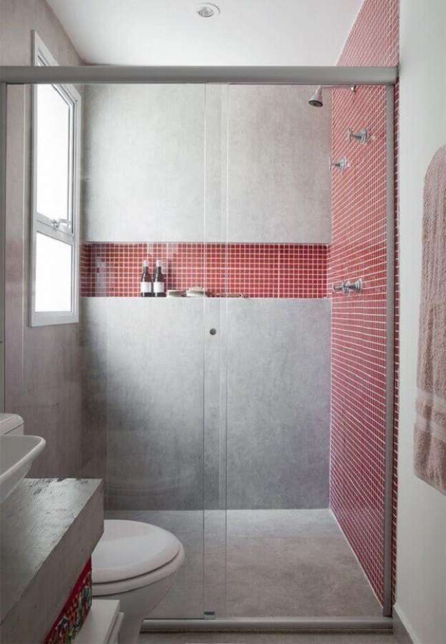 54. Pastilhas vermelhas e parede de cimento queimado para decoração de banheiro moderno com nicho no box – Foto: Futurist Architecture