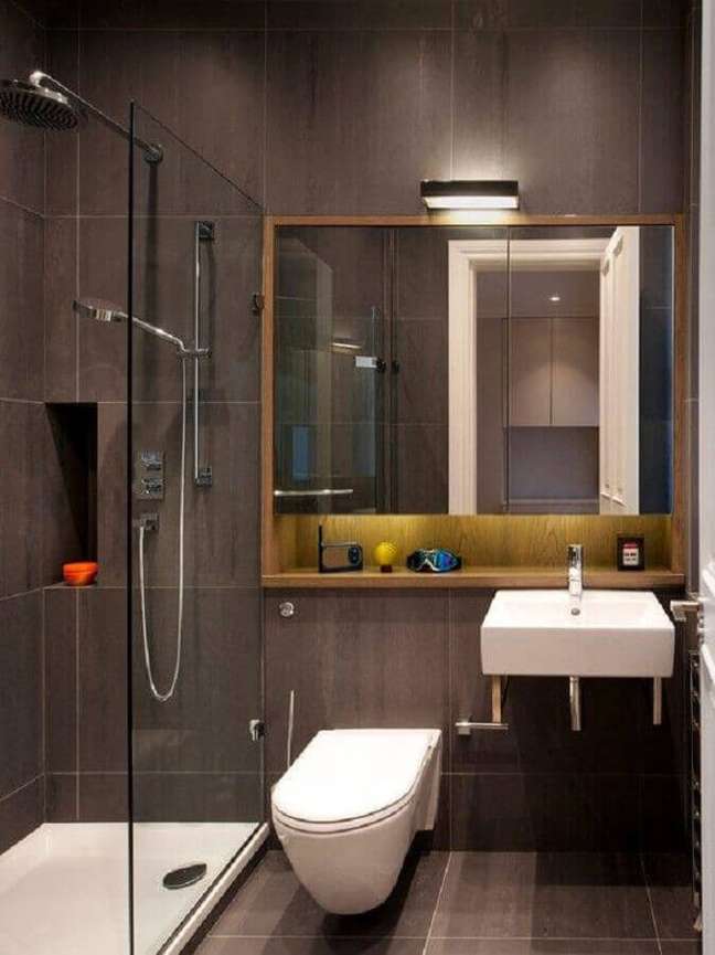 57. Revestimento cinza para decoração de banheiro com nicho de madeira – Foto: HomisHome