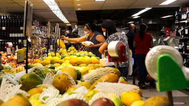 Mulheres escolhem alimentos dentro de supermercado