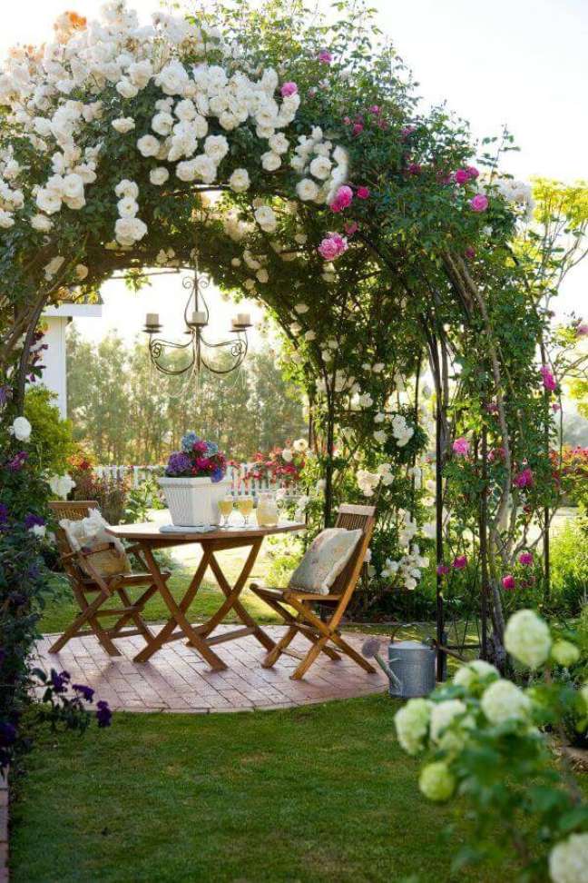 40. Jardim com pergolado e luminária de jardim acima da mesa de madeira – Foto Daily Dream Decor