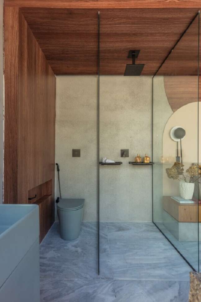 4. Banheiro com revestimento amadeirado e chuveiro preto – Foto PH Nunes