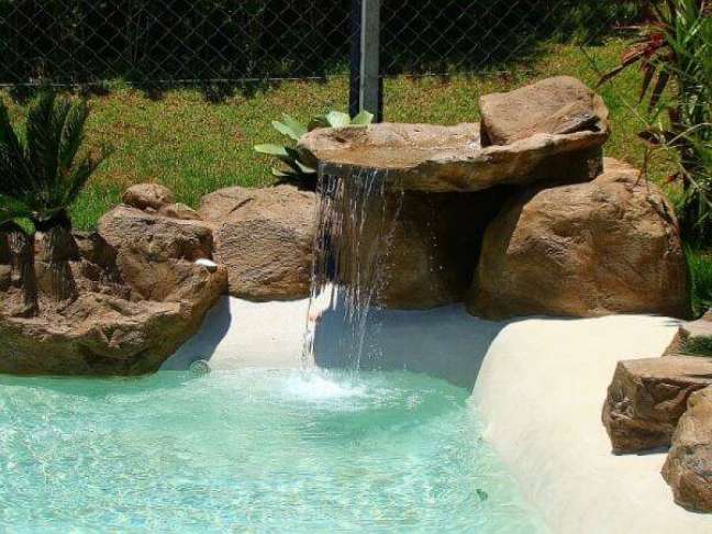 58- A cascata para piscina tem acabamento com pedras artificiais de vários tamanhos e formas. Fonte: Tudo Construção