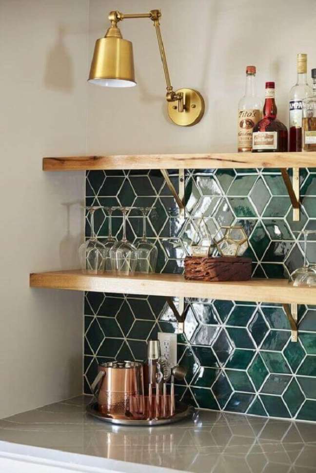 26. Decoração de cozinha com prateleira de madeira e mão francesa cor dourada – Foto Mercury Mosaics