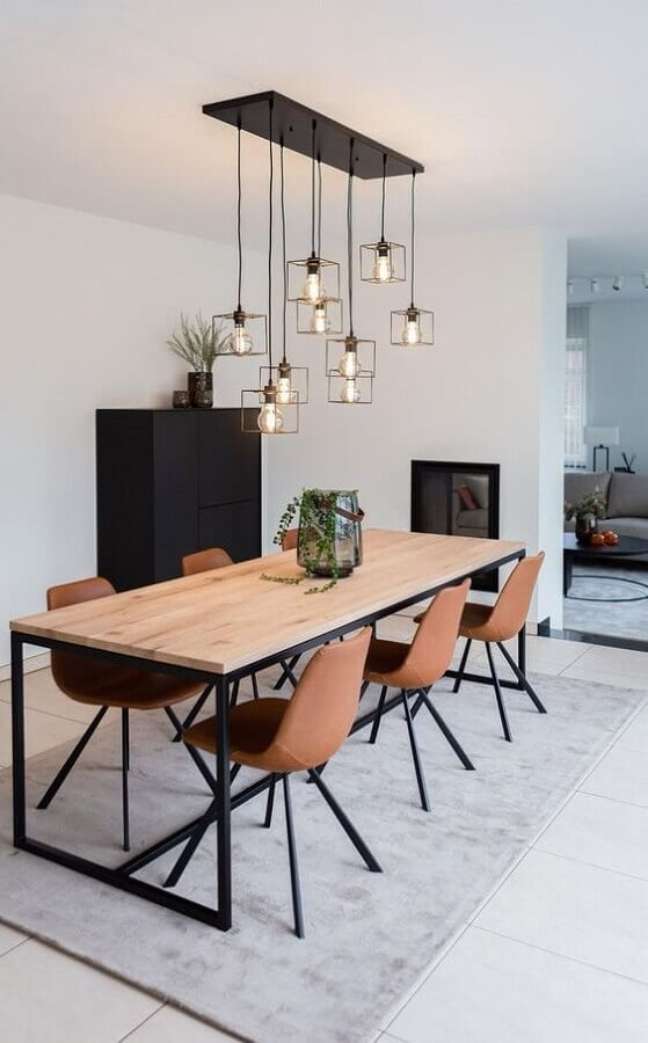 55. Sala de jantar decorada com mesa de madeira e lustre aramado cobre – Foto: Futurist Architecture