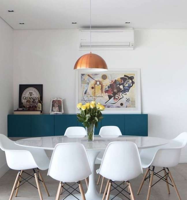 38. Decoração clean para sala de jantar com mesa redonda e buffet azul – Foto: Decor Fácil
