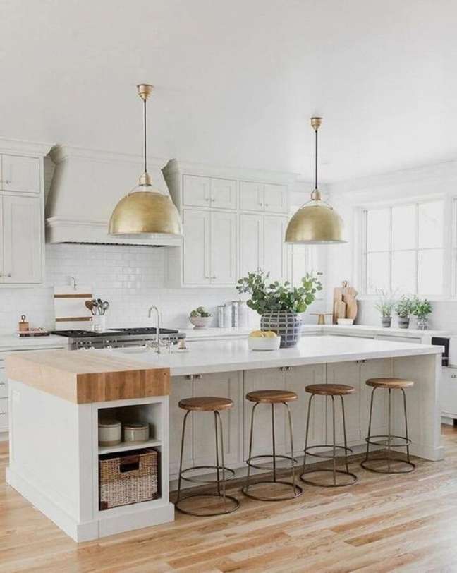 27. Decoração clean para cozinha branca grande com luminária dourada – Foto: McGee & Co