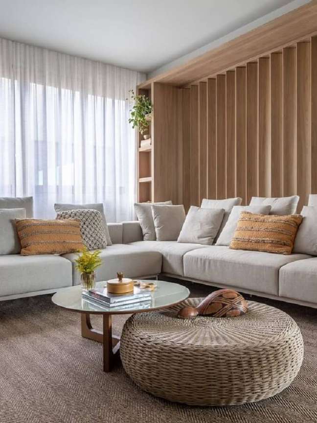 26. Decoração clean para casa em cores neutras com sofá de canto e puff redondo para sala – Foto: Gabriela Daltro