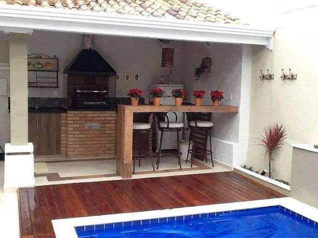 8. Decoração simples para espaço gourmet pequeno com piscina e churrasqueira – Foto: Decor Fácil