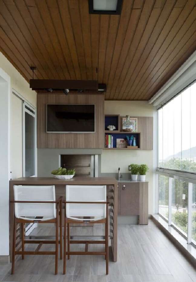 13. Banqueta de madeira para decoração de apartamento com espaço gourmet pequeno com churrasqueira – Foto: Decor Fácil