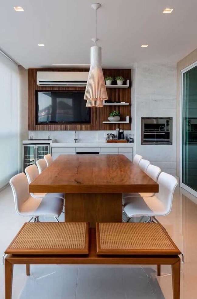 27. Decoração de espaço gourmet pequeno com mesa de madeira e cadeiras brancas – Foto: Decostore
