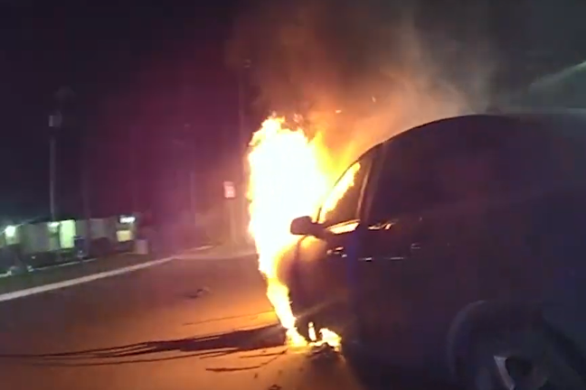 Um vídeo mostra policiais entrando em ação para salvar uma mulher inconsciente que estava presa em um carro em chamas