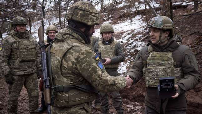 O presidente ucraniano, Volodymyr Zelensky (dir.), visitou tropas de seu país em dezembro