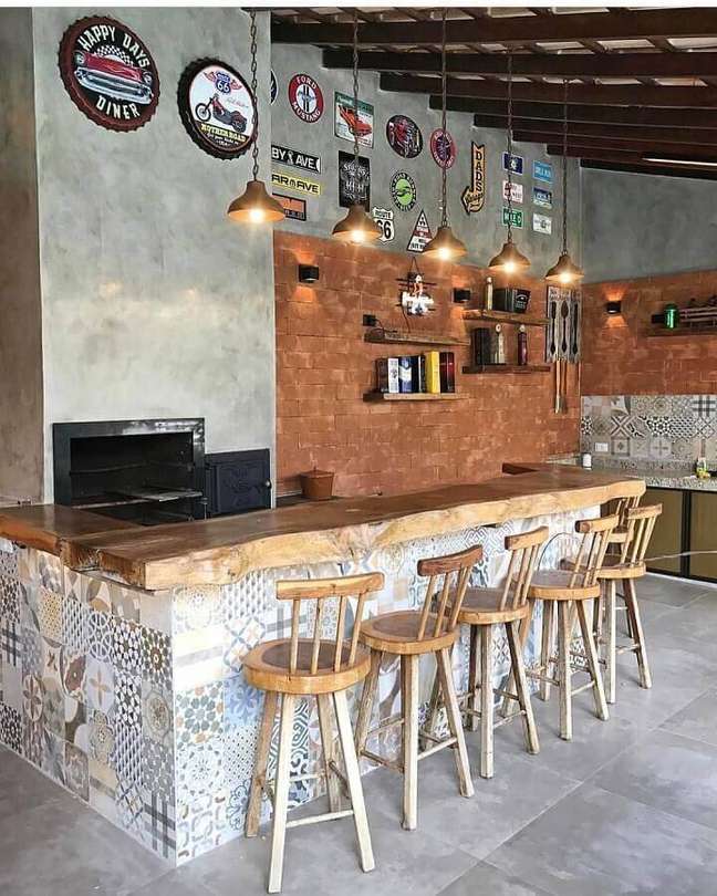 8. Cantinho do churrasco rústico decorado com parede de cimento queimado e bancada de madeira e ladrilho hidráulico – Foto: Decor Fácil