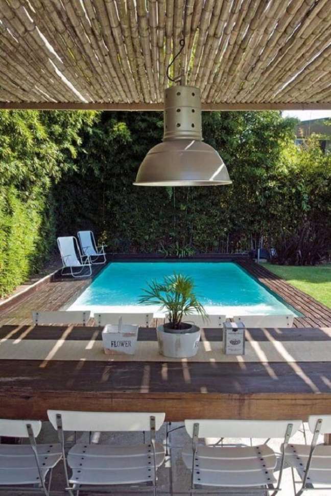 17. Pergolado de de bambu com mesa de madeira perto da piscina quadrada – Foto Decor Trendy