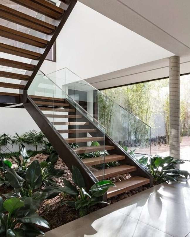 4. Jardim embaixo da escada na sala de estar rústica com corrimão de vidro – Foto Padovani Arquitetos