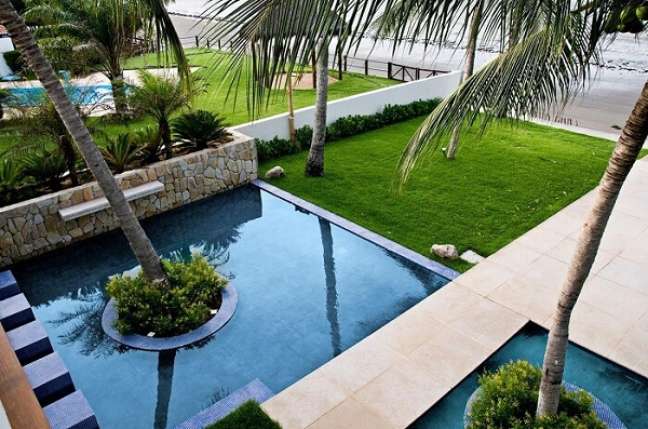 10. Cascata de pedra para piscina quadrada e coqueiros decoram a área externa. Fonte Renato Teles Arquitetura