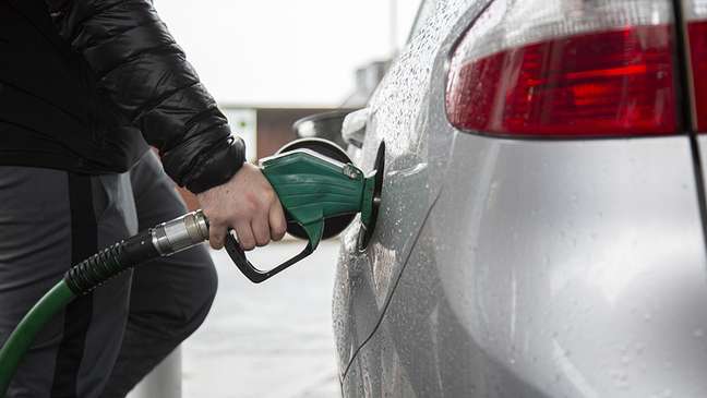 Homem abastecendo carro com gasolina em posto do Reino Unido, fevereiro de 2022