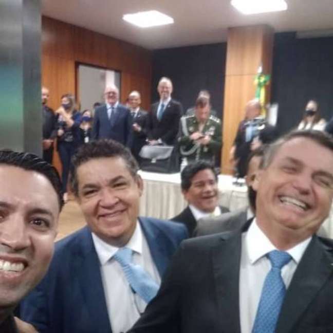  Arilton (à esquerda) e Gilmar (ao fundo) posam sorridentes com Bolsonaro após evento no MEC