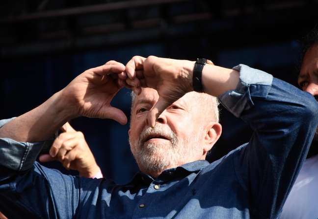 Lula faz gesto com as mãos imitando um coração durante discurso em ato, em comemoração ao 1º de maio.