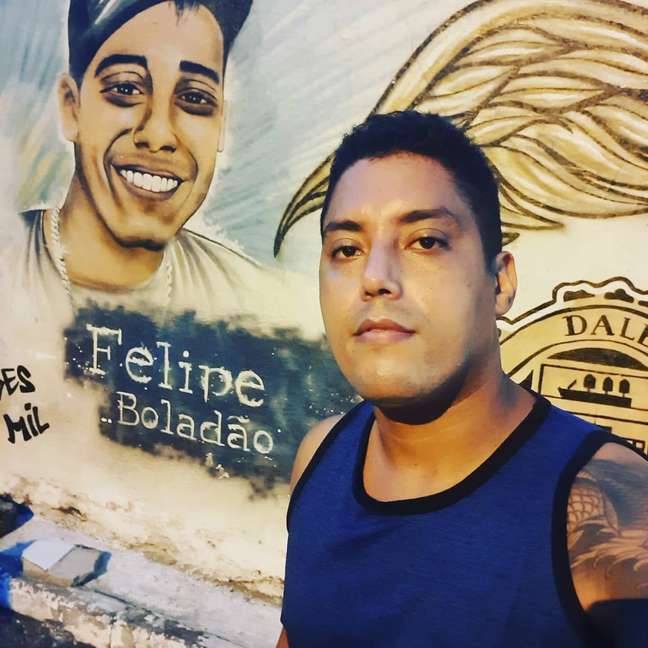 Luizinho da Bacia em frente de grafite do MC Felipe Boladão
