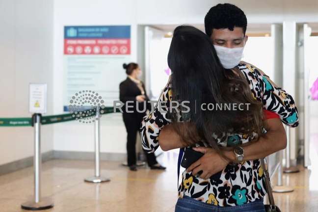 Um homem usando máscara abraça uma mulher em meio ao surto de coronavírus no aeroporto de Viracopos, Campinas16/03/2020REUTERS/Rahel Patrasso