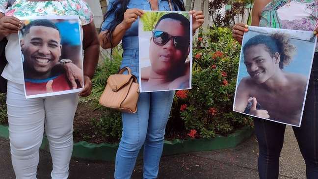 Imagem enquadra cartazes com fotografias de três jovens negros Imagem enquadra cartazes com fotografias de três jovens negros