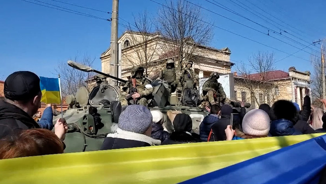 Ativistas pró-Ucrânia em frente a soldados russos durante uma manifestação em Kherson