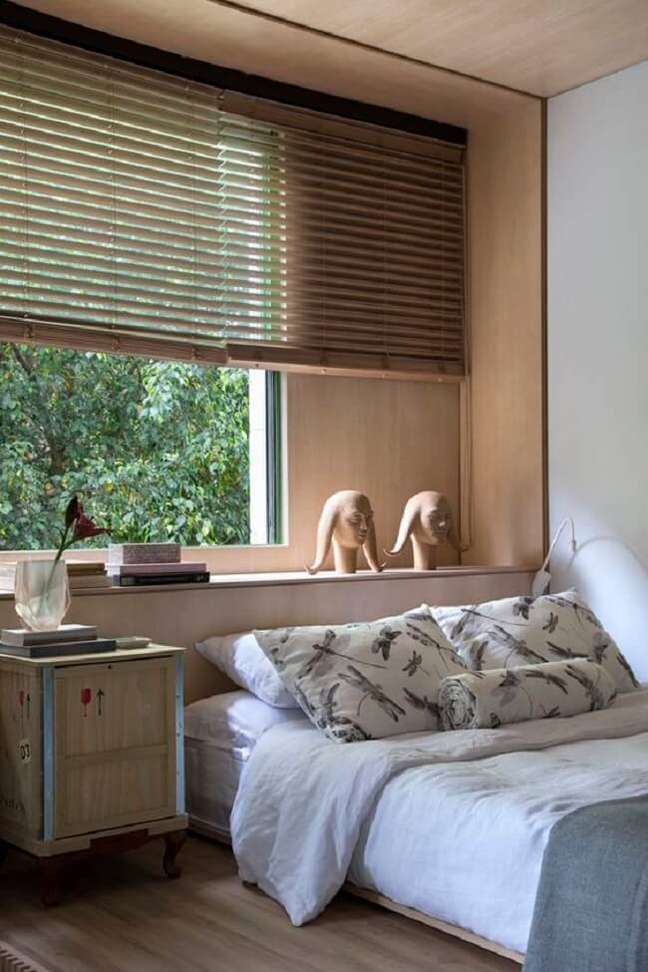 6. Persiana de madeira barram a entrada de luz natural a cama embaixo da janela. Fonte: Casa de Valentina