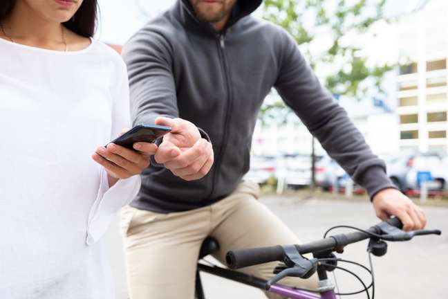 Homem de bicicleta roubando celular