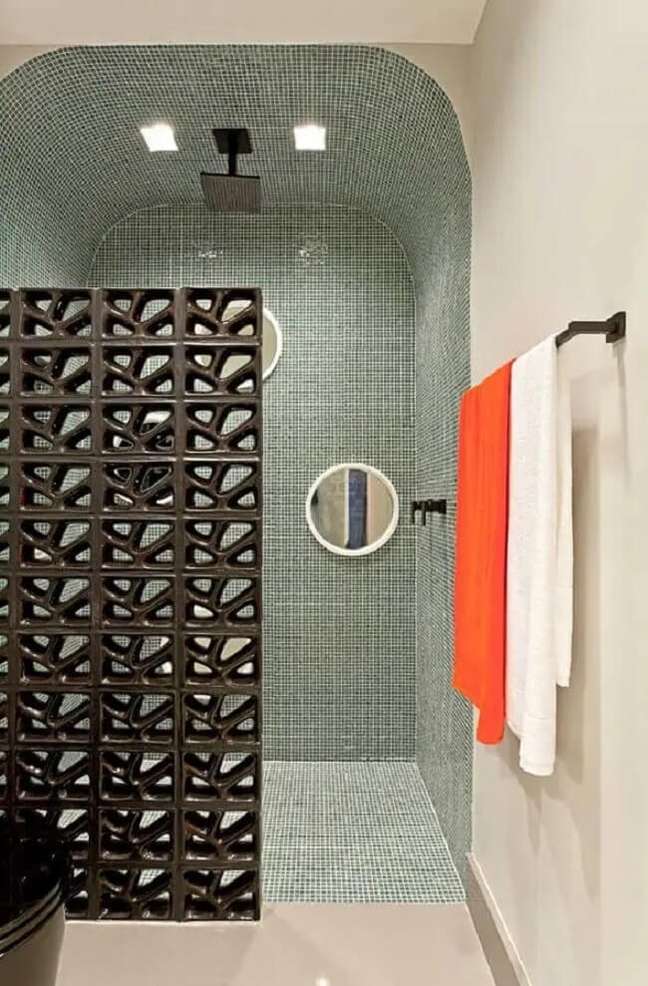 10. Banheiro moderno com pastilhas de vidro e meia parede de cobogó preta. Fonte: Clélia Regina Angelo