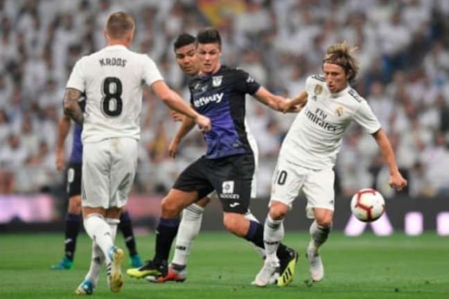 Entrosamento entre Casemiro, Kroos e Modric para marcar o mesmo jogador (Foto: GABRIEL BOUYS / AFP)