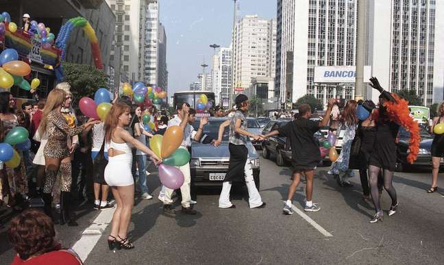 Gays, drag queens e travestis ocupam as vias da Avenida Paulista e interagem com os motoristas durante a segunda edição da Parada do Orgulho LGBT+ de São Paulo, então chamada apenas 'Parada do Orgulho Gay'