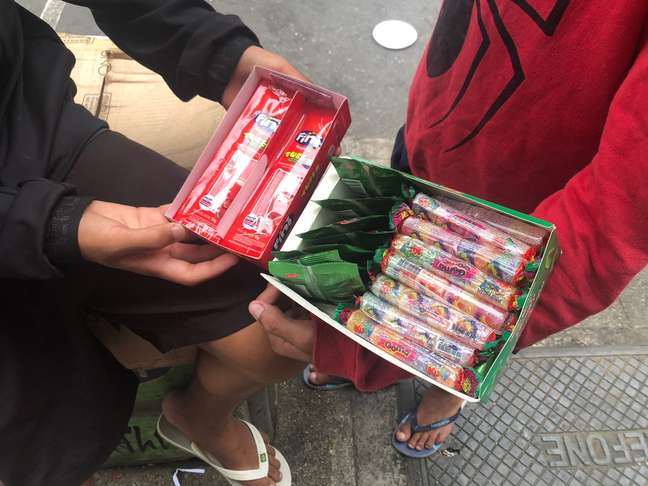 Colleagues, who are minors, work selling candies in Santos