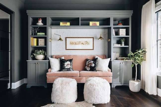 Sala de estar decorada em cinza escuro, com um único sofá na cor rosa