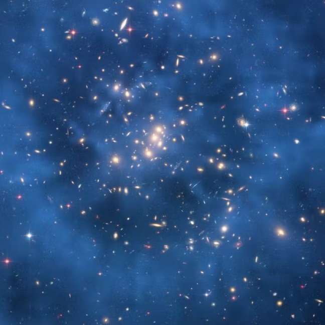 O anel de matéria escura modelado computacionalmente nesta imagem abrange cerca de cinco milhões de anos-luz e foi sobreposto digitalmente à imagem ao fundo, em azul difuso. Essa formação aconteceu quando duas galáxias colidiram